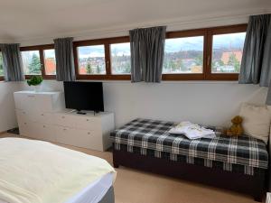 een slaapkamer met een bed, een tv en ramen bij Residence Sarka Top in Praag +21 foto's