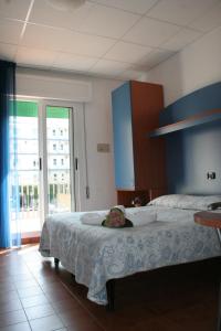 a bedroom with a bed and a large window at Hotel Trifoglio in Lido di Jesolo
