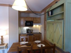 een kleine keuken met een houten tafel en een kamer bij Ski-in ski-out 1 bedroom apartment Arc 1950 in Bourg-Saint-Maurice