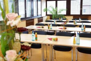 a classroom with tables and chairs with food on them at Art-Hotel Sonnenhof in Hanau am Main
