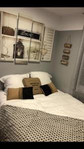 een slaapkamer met een wit bed en enkele planken bij Les pieds dans l'eau SWEET HOME in Corné