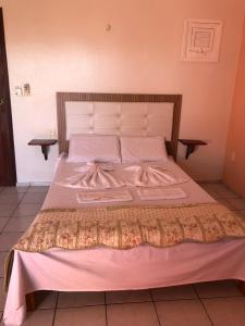 a bed with white blankets and pillows on it at Bela Vista in Canoa Quebrada