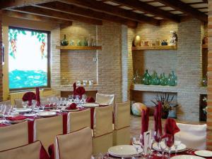 uma sala de jantar com uma mesa longa com guardanapos vermelhos em Hotel Las Moreras em León