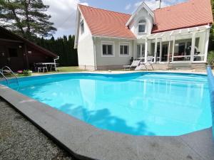 a swimming pool in front of a house at Relax Apartman Bükfürdő in Bükfürdő