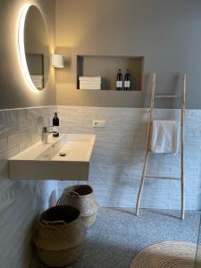 a bathroom with a sink and a mirror and baskets at KASerne Boutique Hotel in Den Bosch