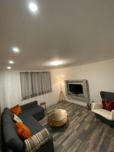 a living room with a couch and a tv at Hollemeadow in Bloxwich