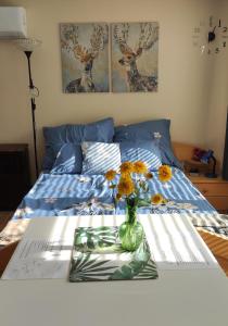 una mesa con un jarrón de flores en una cama en Fenyves-lak en Szalkszentmárton