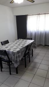 a dining room with a table and chairs and a window at Casa Necochea in Necochea