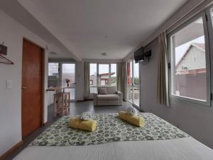 1 dormitorio con 1 cama con 2 almohadas amarillas en Cabañas Agreste, en Villa Gesell 81 fotos más