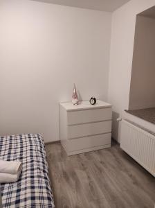 um quarto branco com uma cama e uma cómoda em Apartament Krakowska em Czestochowa