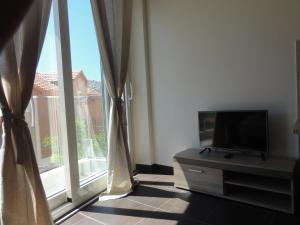 a living room with a tv and a large window at The Old Town Viewpoint Apartments in Budva