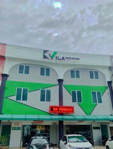 un gran edificio con coches estacionados frente a él en K VILA HOTEL, en Sungai Petani