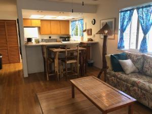ein Wohnzimmer und eine Küche mit einem Sofa und einem Tisch in der Unterkunft Ala Kai Bed and Breakfast in Keaau