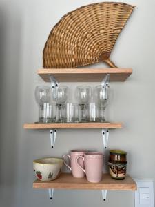 a shelf with bowls and cups and a basket at Departamento en Pichincha in Rosario