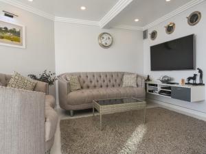 a living room with a couch and a tv at Apartment 39 in Millbrook