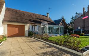 une maison avec garage dans une cour dans l'établissement La Plaisance C.L.S Deauville, à Touques