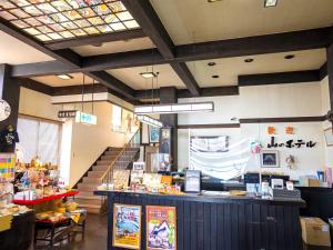 a restaurant with a counter and stairs in a room at Dake Onsen Yamano Hotel in Hirosaki