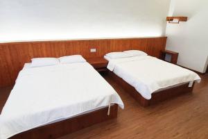 two beds in a room with wooden floors at [New!] Jonker Street Loft 3BR Melaka 10PAX in Melaka