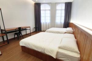 a bedroom with two beds and a desk and a table at [New!] Jonker Street Loft 3BR Melaka 10PAX in Melaka