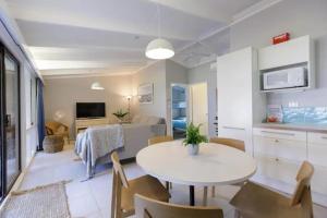 a kitchen and living room with a table and chairs at Sandpiper On Smiths Lake in Smiths Lake +1 photo