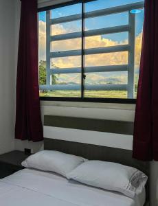 - une chambre dotée d'une fenêtre avec un lit et un oreiller dans l'établissement Sagrado Hotel, à Aguachica