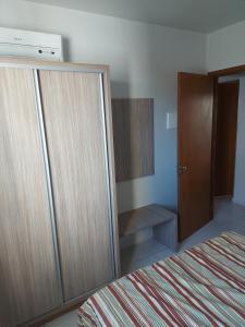 een slaapkamer met een grote houten kast naast een bed bij Riviera park Thermas Flat 1 in Caldas Novas