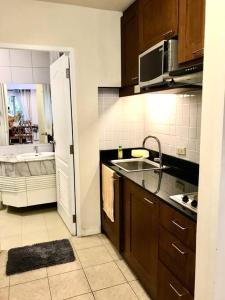 a kitchen with a sink and a bathroom with a tub at Baan Talay Samran relaxing with garden view (2 BR) in Ban Khlong Khot +2 photos