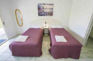 two beds are in a room with a wall at Agnes Palms Accommodation in Agnes Water