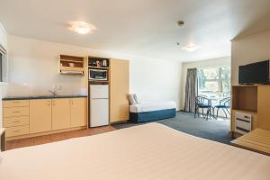 a room with a kitchen and a bed in a room at Blue Peaks Lodge in Queenstown