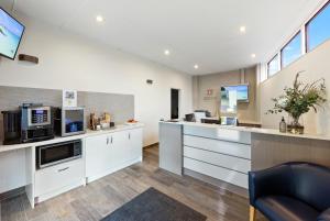 a kitchen with white cabinets and a counter at Fawkner Executive Suites & Serviced Apartments in Melbourne