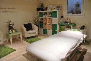 a hospital room with a bed and a chair at Alpenhotel Hundsreitlehen in Bischofswiesen