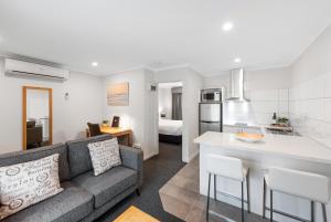 a living room and kitchen with a couch and a counter at Fawkner Executive Suites & Serviced Apartments in Melbourne