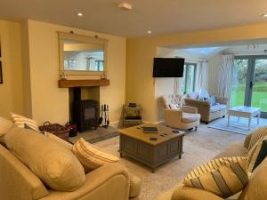 a living room with two couches and a fireplace at Penrhyn Farm in Penrhos-Lligwy