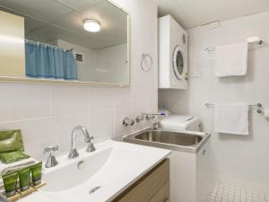 ein weißes Badezimmer mit Waschbecken und Spiegel in der Unterkunft Tanderra 10 on Park Road in Jindabyne + 13 Fotos