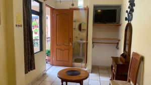 een hal met een deur en een tafel en een televisie bij Posada El Campanario in Valle de Bravo