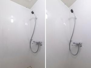 two shower stalls in a bathroom with white walls at Tabist Hotel Miyakonojo Miyazaki in Miyakonozyō