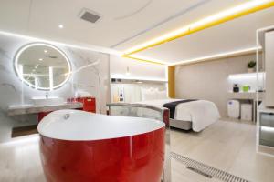 a bathroom with a tub and a bedroom with a bed at 168 Motel-Zhongli in Zhongli