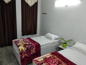 a hotel room with two beds and a window at Videep house in Kānpur