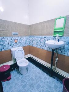 a bathroom with a toilet and a sink at Kinabalu Valley Guesthouse in Kundasang
