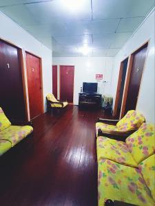 a living room with two couches and a television at Kinabalu Valley Guesthouse in Kundasang