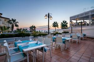 a restaurant with tables and chairs on a patio at Iz Flower Side Beach Hotel in Side