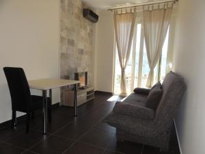 a living room with a table and a chair and a couch at The Old Town Viewpoint Apartments in Budva