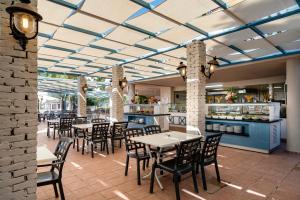 a restaurant with tables and chairs and a kitchen at Iz Flower Side Beach Hotel in Side