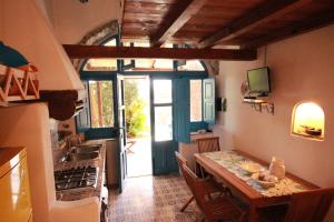 cocina con mesa y cocina con puerta en La Casa di Via Lungomare, en Santa Marina Salina