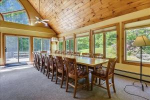 a dining room with a long table and chairs at Sunburst in Killington