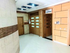 un pasillo con puertas de madera en un edificio en Appartment Majorelle entier au Centre Ville Kenitra en Kenitra