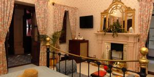 uma sala de estar com lareira e uma escada em Gajner Palace-Heritage by HRH Group of Hotels em Gajner