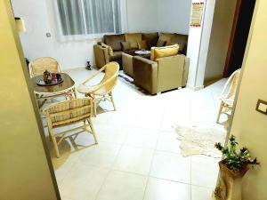 sala de estar con sofá, mesa y sillas en Appartment Majorelle entier au Centre Ville Kenitra en Kenitra