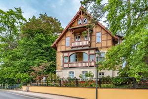 a house with a fence in front of it at Haus auf dem Huegel Appartement 2 in Bansin