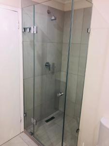a shower with a glass door in a bathroom at 22 Kyalanga Beachfront Apartment in Durban